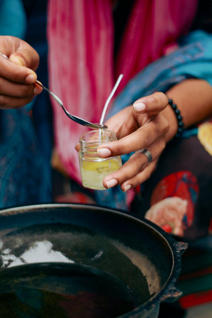 Hands crafting eco-friendly candles using organic ingredients in Dhaka, Bangladesh.